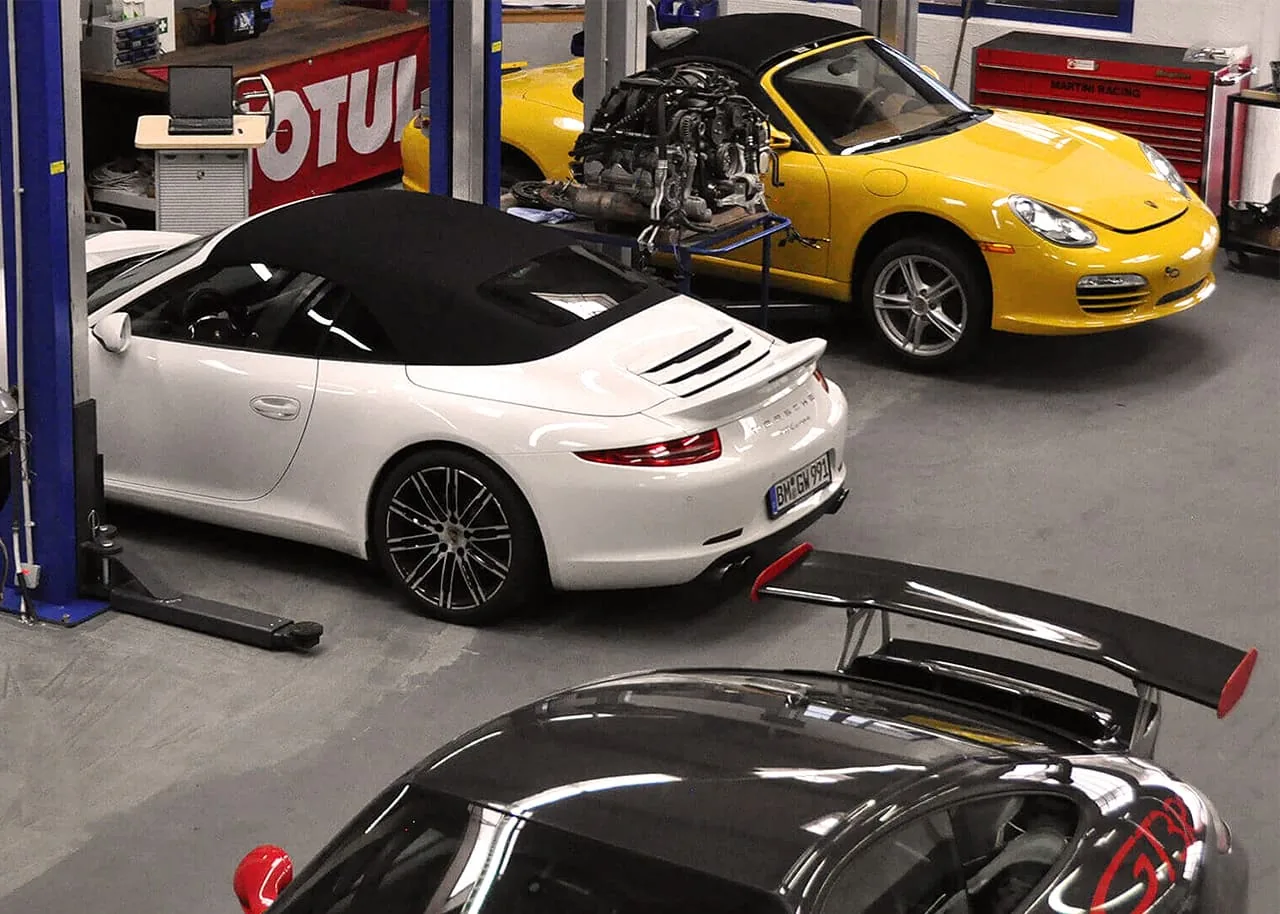 Mehrere Porsche 911 und ein Boxster auf den Hebebühnen der Roock Werkstatt